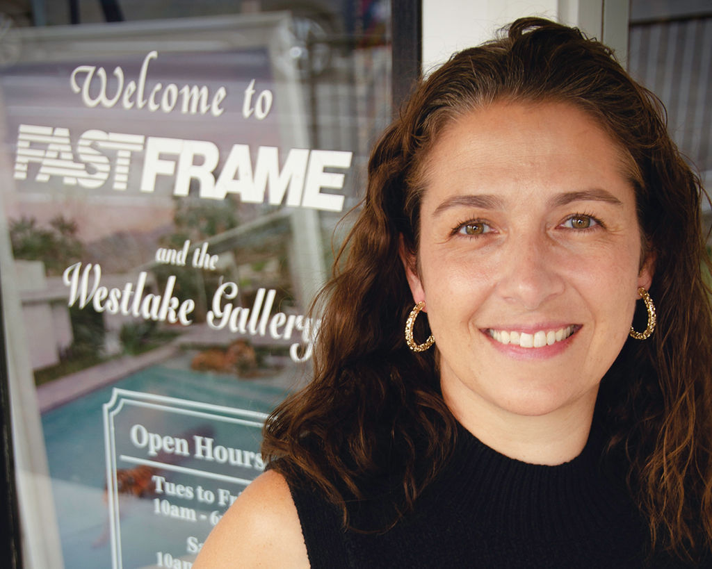 custom picture frame shop owner in front of store sign